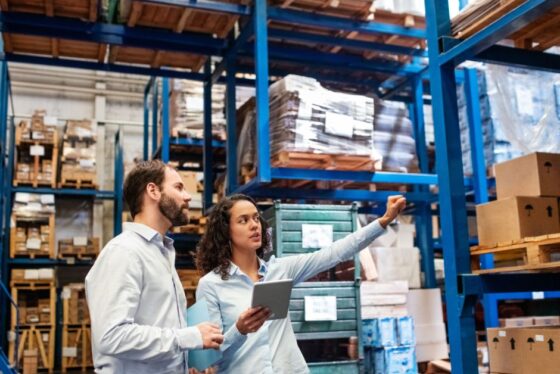Warehouse supervisor with clipboard training a new hire in a Richmond VA facility