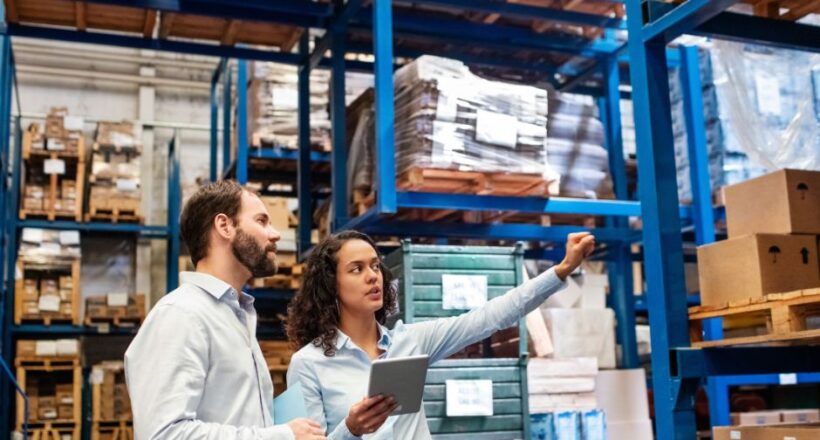 Warehouse supervisor with clipboard training a new hire in a Richmond VA facility