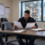 Hiring manager reviewing and comparing two documents at a desk at a warehouse facility.