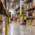 Long warehouse aisle with shelving and a worker in a distribution center