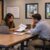 Two professionals reviewing a staffing proposal at a table